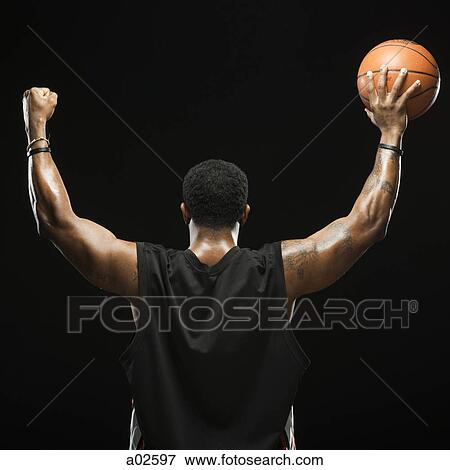 Studio shot of basketball player holding ball, rear view View Large Photo Image Stock Photo - Studio shot of basketball player holding ball, rear view. Fotosearch