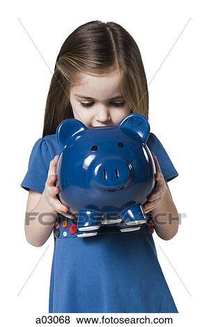 Stock Photo - Studio shot of girl (4-5) holding piggy bank. Fotosearch
