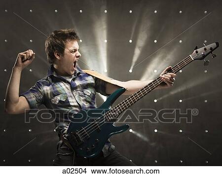 Picture - Studio shot of guitarist playing on electric guitar. Fotosearch