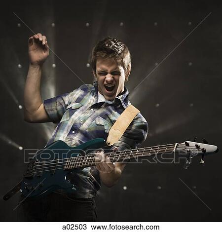 Studio shot of guitarist playing on electric guitar View Large Photo Image Stock Image - Studio shot of guitarist playing on electric guitar. Fotosearch