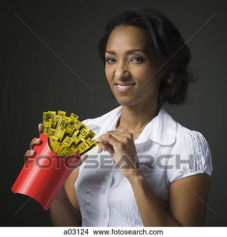 Studio shot of mid adult woman holding patch with yellow measure taps and smiling View Large Photo Image Picture - Studio shot of mid adult woman holding patch with yellow measure taps and smiling. Fotosearch