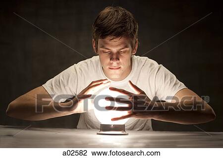 Studio shot of young man with hands around glowing crystal ball View Large Photo Image Stock Image - Studio shot of young man with hands around glowing crystal ball. Fotosearch
