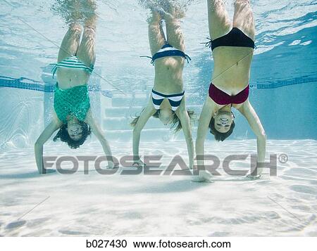 teenagers in a swimming pool doing handstands under water View Large Photo Image Stock Image - teenagers in a swimming pool doing handstands under water. Fotosearch