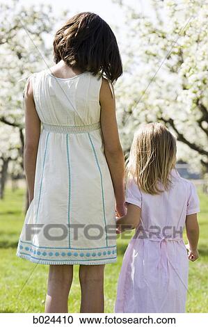 two girls in a blossoming orchard View Large Photo Image Stock Image - two girls in a blossoming orchard. Fotosearch
