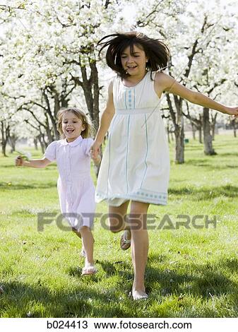 two girls in a blossoming orchard View Large Photo Image Stock Image - two girls in a blossoming orchard. Fotosearch