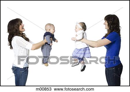 Stock Image - two mothers holding their babies face to face. Fotosearch
