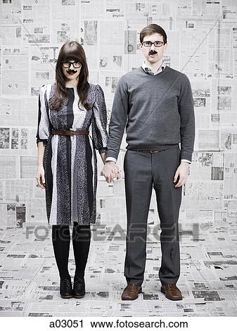 Two young people with fake mustache standing in newspapers covered room, studio shot View Large Photo Image Stock Image - Two young people with fake mustache standing in newspapers covered room, studio shot. Fotosearch
