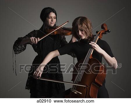 Stock Image - Two young women playing string instruments. Fotosearch