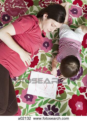 Stock Image - USA, California, San Francisco, pregnant mother with daughter (2-3) coloring. Fotosearch