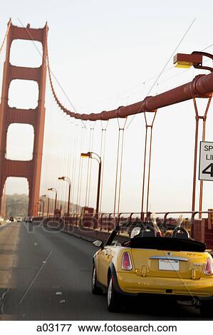 Stock Photo - USA, California, San Francisco, yellow car on Golden Gate Bridge. Fotosearch