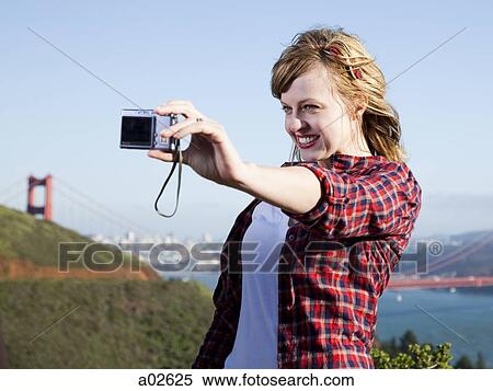USA, California, San Francisco, young woman taking pictures of herself, Golden Gate Bridge in background View Large Photo Image Stock Photography - USA, California, San Francisco, young woman taking pictures of herself, Golden Gate Bridge in background. Fotosearch