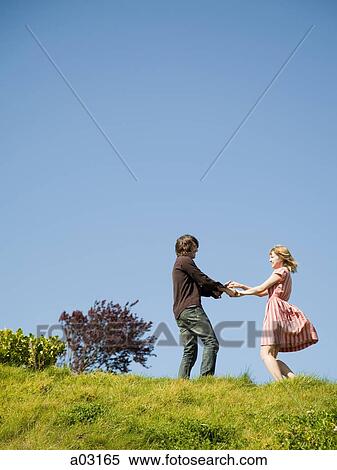 Stock Photography - USA, California, San Francisco, young couple holding hands on hill. Fotosearch