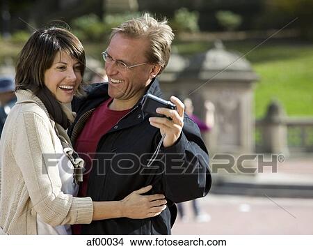 Picture - USA, New York City, Manhattan, Central Park, Mature couple photographing themselves in Central Park. Fotosearch