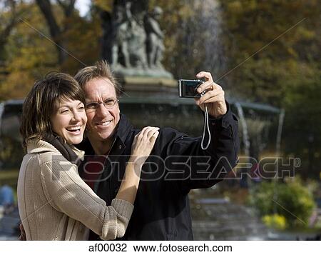 USA, New York City, Manhattan, Central Park, Mature couple photographing themselves in Central Park View Large Photo Image Stock Image - USA, New York City, Manhattan, Central Park, Mature couple photographing themselves in Central Park. Fotosearch