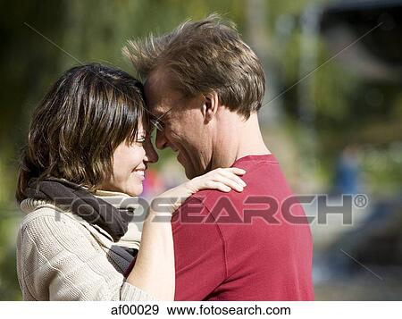 Stock Photo - USA, New York City, Manhattan, Central Park, Mature couple embracing in Central Park. Fotosearch
