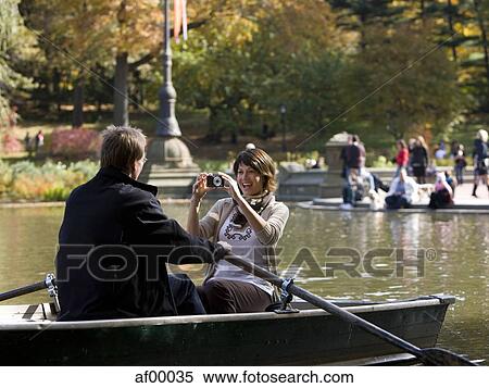 USA, New York City, Manhattan, Central Park, Mature woman photographing man in boat in Central Park View Large Photo Image Stock Photography - USA, New York City, Manhattan, Central Park, Mature woman photographing man in boat in Central Park. Fotosearch