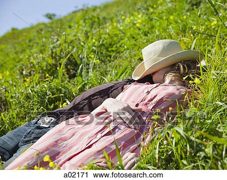 Stock Image - USA, San Francisco, California, young couple lying on grass. Fotosearch