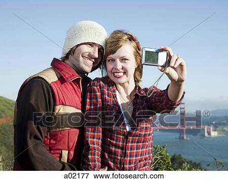 USA, San Francisco, California, young couple photographing self with Golden Gate Bridge in background View Large Photo Image Stock Photo - USA, San Francisco, California, young couple photographing self with Golden Gate Bridge in background. Fotosearch