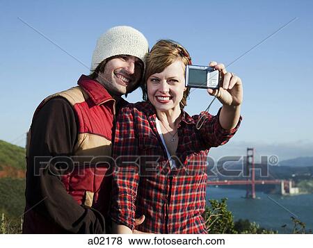 USA, San Francisco, California, young couple photographing self with Golden Gate Bridge in background View Large Photo Image Stock Photo - USA, San Francisco, California, young couple photographing self with Golden Gate Bridge in background. Fotosearch