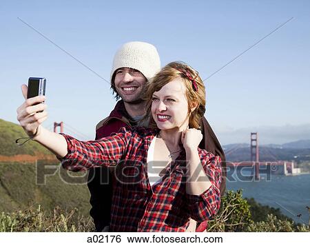 USA, San Francisco, California, young couple photographing self with Golden Gate Bridge in background View Large Photo Image Stock Photograph - USA, San Francisco, California, young couple photographing self with Golden Gate Bridge in background. Fotosearch