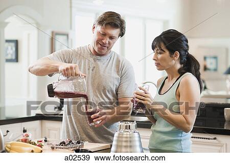 USA, Utah, Alpine, couple standing in kitchen and pouring fruit cocktail View Large Photo Image Stock Photo - USA, Utah, Alpine, couple standing in kitchen and pouring fruit cocktail. Fotosearch