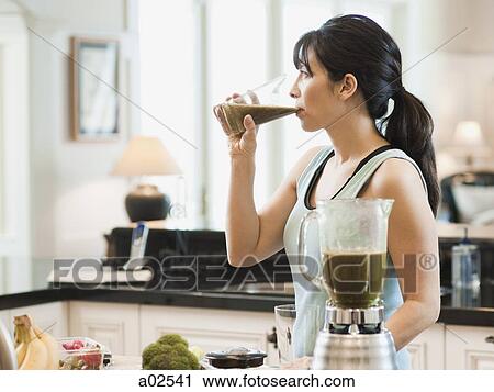 USA, Utah, Alpine, mid adult woman standing in kitchen and drinking cocktail View Large Photo Image Stock Image - USA, Utah, Alpine, mid adult woman standing in kitchen and drinking cocktail. Fotosearch