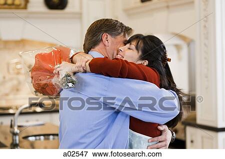 USA, Utah, Alpine, mid adult woman greeting man at home View Large Photo Image Stock Photo - USA, Utah, Alpine, mid adult woman greeting man at home. Fotosearch