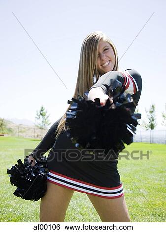 Stock Photograph - USA, Utah, American Fork, Portrait of smiling cheerleader holding pom-pom. Fotosearch