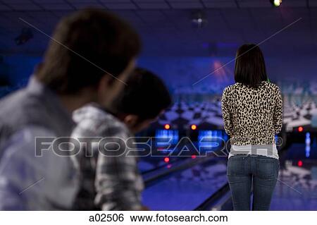 Stock Photograph - USA, Utah, American Fork, rear view of girl standing in bowling alley. Fotosearch