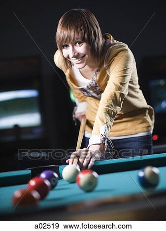 Stock Photo - USA, Utah, American Fork, young woman playing pool. Fotosearch