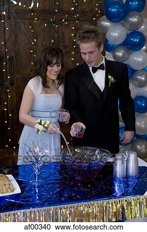 Stock Image - USA, Utah, Cedar Hills, Young couple pouring drinks at birthday party. Fotosearch