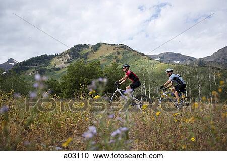 Stock Image - USA, Utah, couple mountain biking. Fotosearch