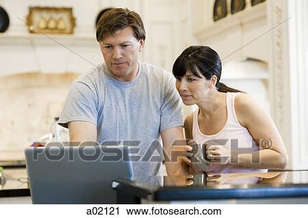 USA, Utah, couple using laptop in kitchen View Large Photo Image Stock Image - USA, Utah, couple using laptop in kitchen. Fotosearch