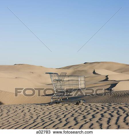Stock Image - USA, Utah, Little Sahara, abandoned shopping cart on desert. Fotosearch