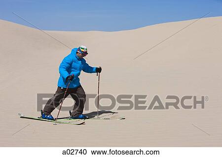 Stock Image - USA, Utah, Little Sahara, man skiing in desert. Fotosearch