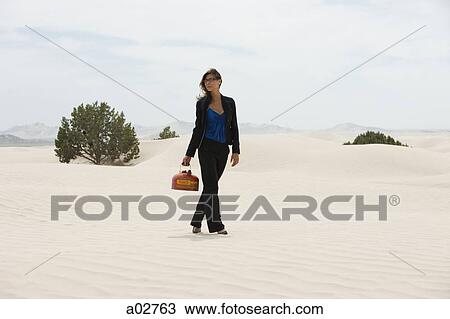 USA, Utah, Little Sahara, young businesswoman walking on desert carrying gas can View Large Photo Image Stock Image - USA, Utah, Little Sahara, young businesswoman walking on desert carrying gas can. Fotosearch