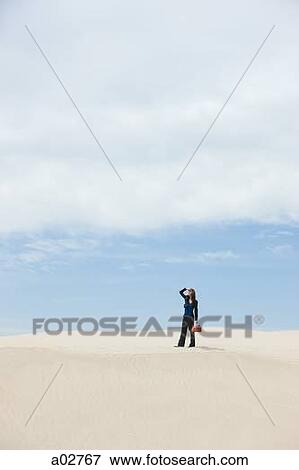 USA, Utah, Little Sahara, young businesswoman standing on desert carrying gas can View Large Photo Image Stock Photo - USA, Utah, Little Sahara, young businesswoman standing on desert carrying gas can. Fotosearch
