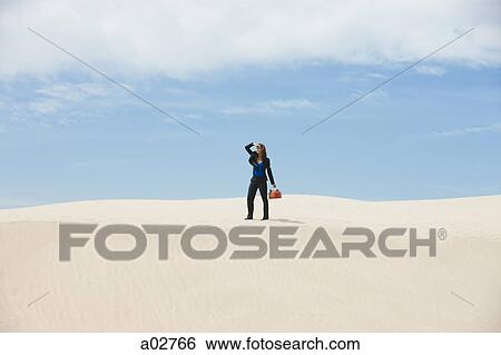 USA, Utah, Little Sahara, young businesswoman standing on desert carrying gas can View Large Photo Image Stock Photograph - USA, Utah, Little Sahara, young businesswoman standing on desert carrying gas can. Fotosearch