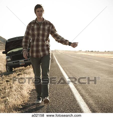 USA, Utah, man hailing on road, broken car in background View Large Photo Image Stock Photo - USA, Utah, man hailing on road, broken car in background. Fotosearch