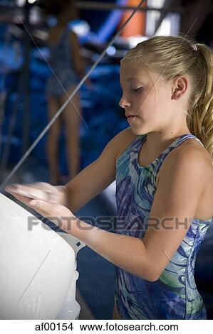 Picture - USA, Utah, Orem, girl (10-11) in gym applying talcum powder to hands. Fotosearch