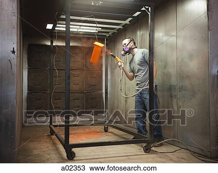 Stock Image - USA, Utah, Orem, man using paint spray gun. Fotosearch