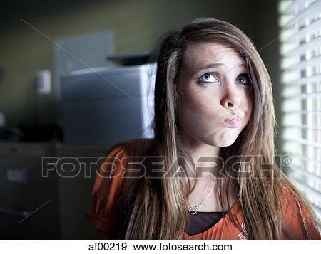 Stock Photo - USA, Utah, Orem, Portrait of young woman grimacing. Fotosearch