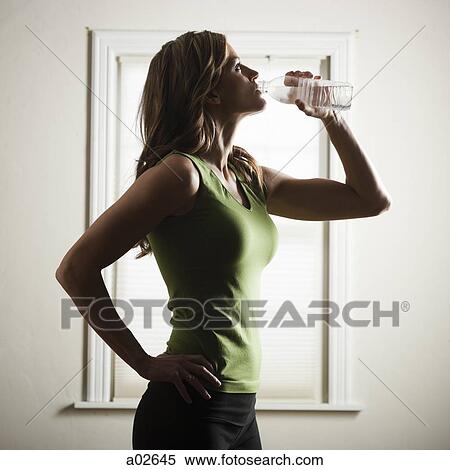 USA, Utah, Orem, young woman standing and drinking water View Large Photo Image Stock Photography - USA, Utah, Orem, young woman standing and drinking water. Fotosearch