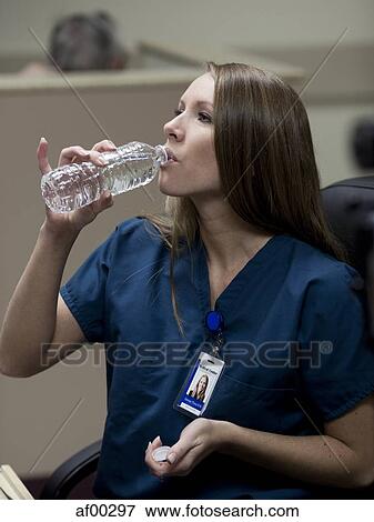 USA, Utah, Payson, Female doctor drinking water View Large Photo Image Stock Photo - USA, Utah, Payson, Female doctor drinking water. Fotosearch