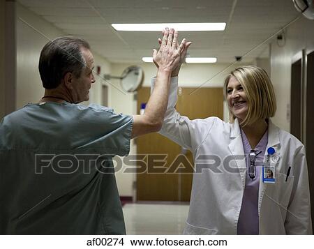 Picture - USA, Utah, Payson, Mature doctors making high five. Fotosearch