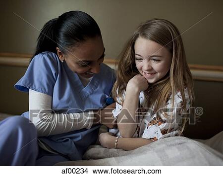 USA, Utah, Payson, Young nurse playing with girl (8-9) View Large Photo Image Picture - USA, Utah, Payson, Young nurse playing with girl (8-9). Fotosearch