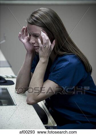 Stock Image - USA, Utah, Payson, Young nurse with headache. Fotosearch