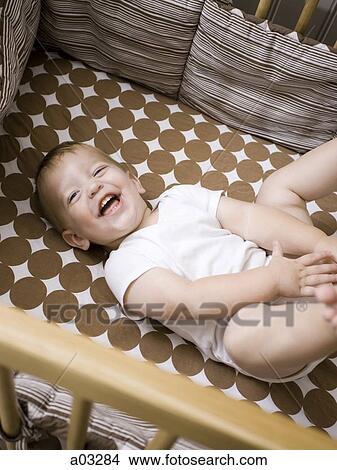 USA, Utah, Provo, Baby boy (18-23 months) lying in crib View Large Photo Image Picture - USA, Utah, Provo, Baby boy (18-23 months) lying in crib. Fotosearch