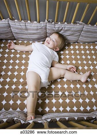 USA, Utah, Provo, Baby boy (18-23 months) lying in crib View Large Photo Image Stock Photograph - USA, Utah, Provo, Baby boy (18-23 months) lying in crib. Fotosearch