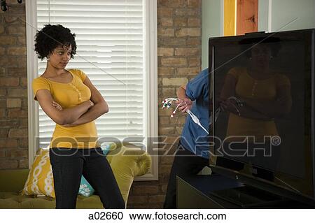 Stock Image - USA, Utah, Provo, couple installing new TV set. Fotosearch